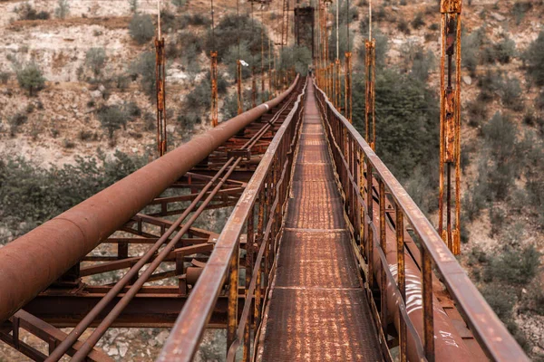 乾燥した川側の眺めの上に古い鉄の機能しないつり橋 モルドバの古い歩道橋 — ストック写真