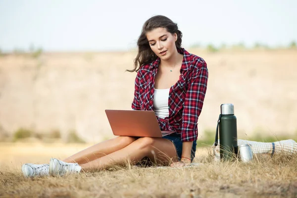 Office outdoors. Beautiful girl works on a laptop in the open air. woman freelancer. Freelance worker concept.