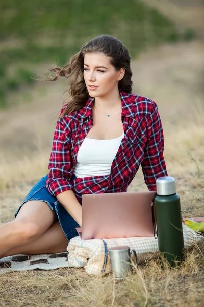 Office outdoors. Beautiful girl works on a laptop in the open air. woman freelancer. Freelance worker concept.