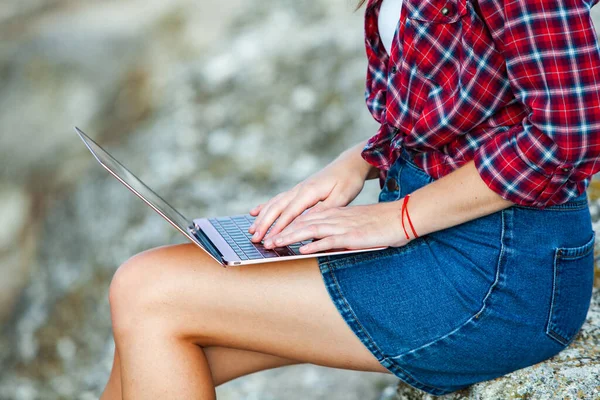 Office outdoors. Beautiful girl works on a laptop in the open air. woman freelancer. Freelance worker concept.