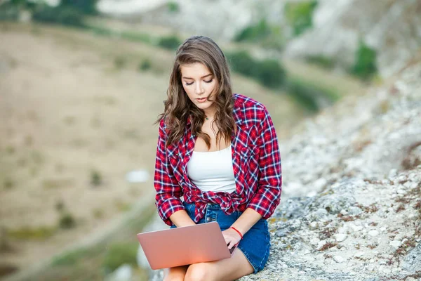 Office outdoors. Beautiful girl works on a laptop in the open air. woman freelancer. Freelance worker concept.