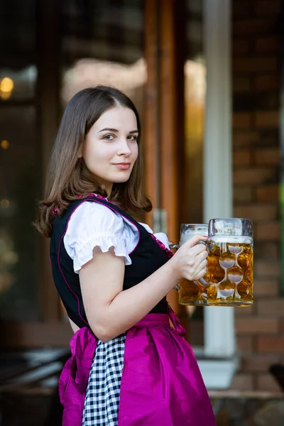 Όμορφη Oktoberfest Κορίτσι Φορώντας Ένα Παραδοσιακό Βαυαρικό Φόρεμα Κρατώντας Κούπες — Φωτογραφία Αρχείου