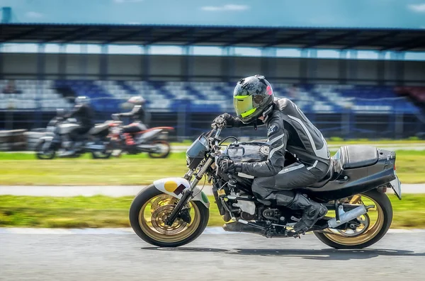 Motociclista en moto deportiva inclinado en una esquina rápida en la pista — Foto de Stock