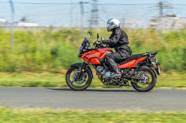 Motosikletçiler bir motosiklet üzerinde bir ülke yolda gidiyor. Hareket bulanıklığı