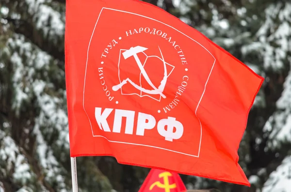 La bandera del Partido Comunista de la Federación Rusa contra el telón de fondo de los abetos cubiertos de nieve. La inscripción en la bandera "Partido Comunista - Partido Comunista de la Federación Rusa " — Foto de Stock