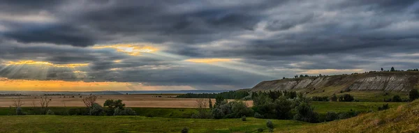 Summer pre-storm landscape. The evening sun shines through the clouds