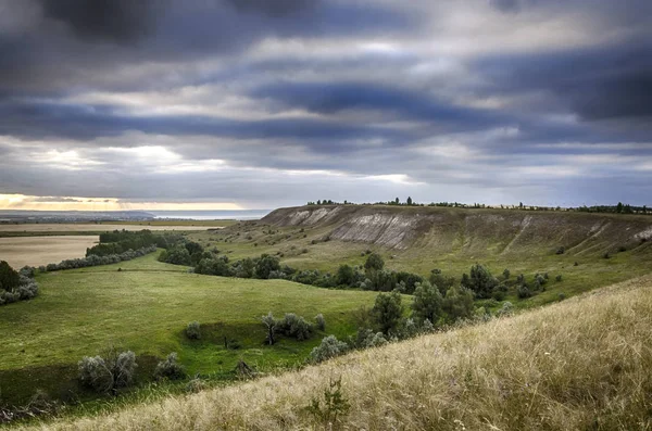 Summer pre-storm landscape. The evening sun shines through the clouds