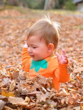  mutlu küçük bir çocuk, gülen ve sonbaharda oynayan kız bebek