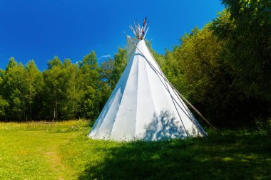 Beyaz kızılderili çadırı güzel yaz manzarasında duruyor..