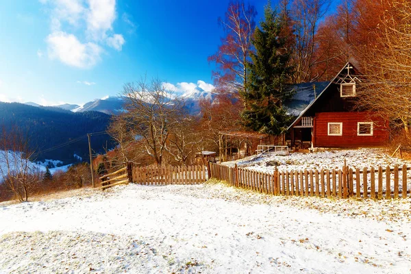 Bellissimo paesaggio innevato di montagna con cottage. Bella giornata di sole in montagna . Fotografia Stock