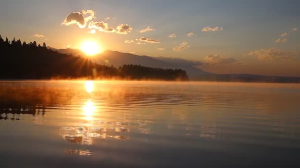 Beautiful landscape with mountains and lake at dawn in golden, blue and purple tones. — Stock Video