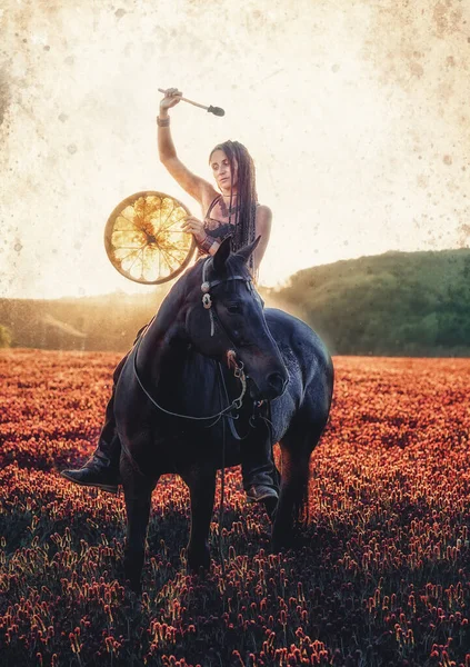 Young dreadded girl with her horse and shamanic frame drum. — Stock Photo, Image