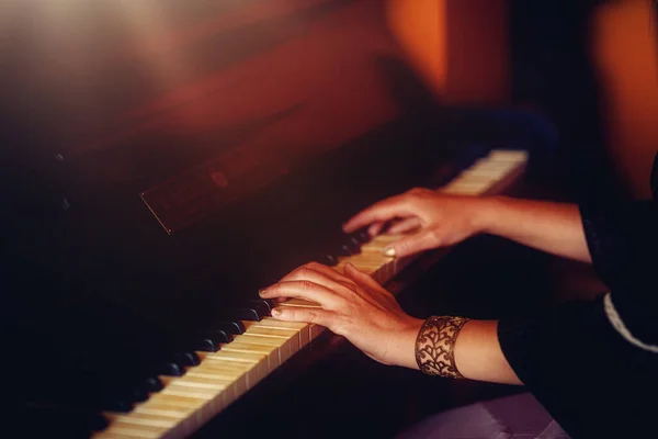 Womans hands on the keyboard of the piano closeup. — Stock Photo, Image