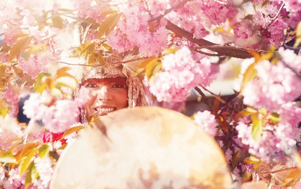 Beautiful shamanic girl playing on shaman frame drum in the nature. — Stock Photo, Image