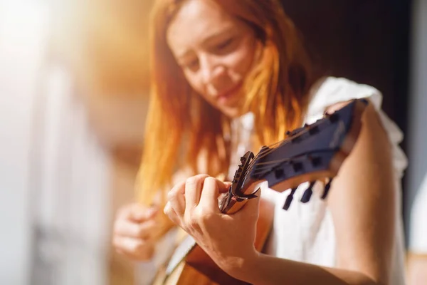 弹吉他的女人和模糊的背景 — 图库照片