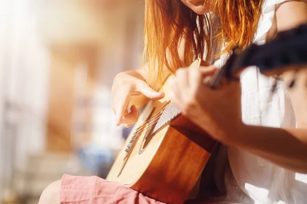 弹吉他的女人和模糊的背景 — 图库照片