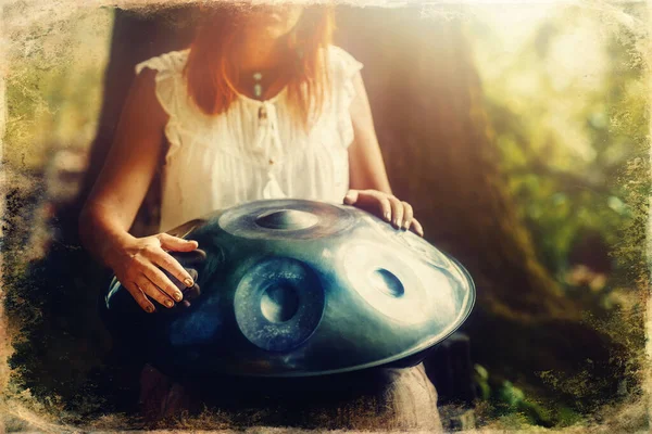 美しい女性が大自然の中でハングドラムで遊ぶ 古い写真効果 — ストック写真