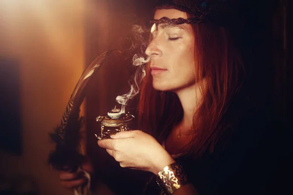 Encens dans une main de femme, fumée d'encens sur fond flou. — Photo