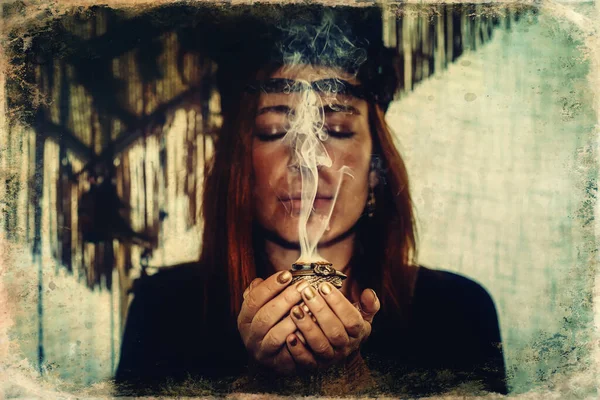 Incense in a woman hand, incense smoke on a black background. Old photo effect. — Stock Photo, Image