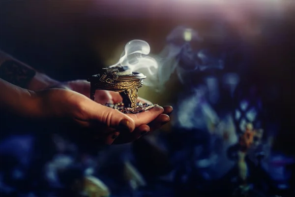 Incense in a woman hand, incense smoke on a black background. — Stock Photo, Image