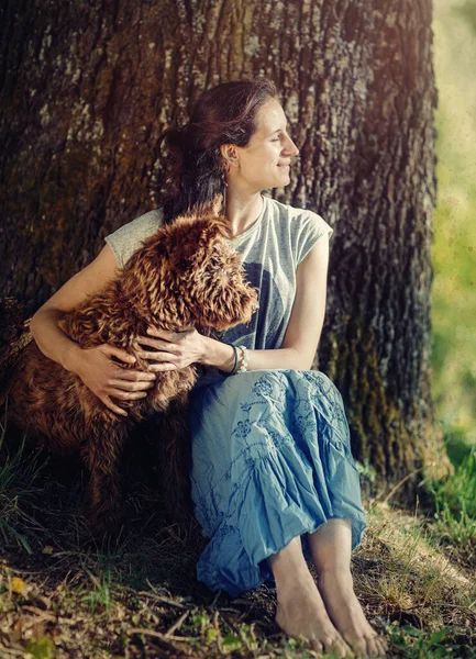 日没時に牧草地で犬と女性が. — ストック写真