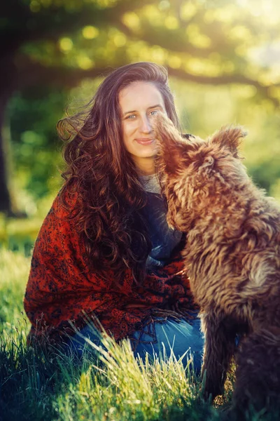 Mujer y perro en el prado al atardecer. — Foto de Stock