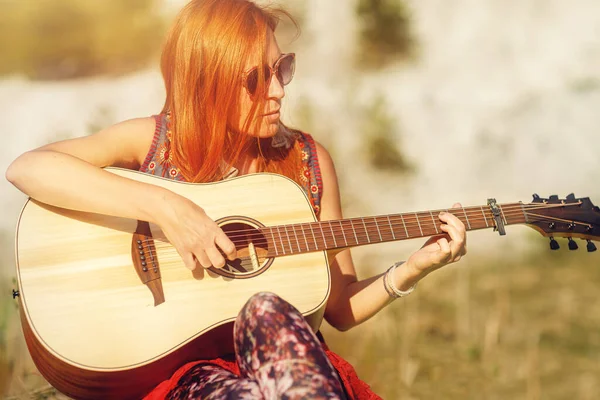 Woman playing with guitar and blurred background. Old photo effect. — Stock Photo, Image