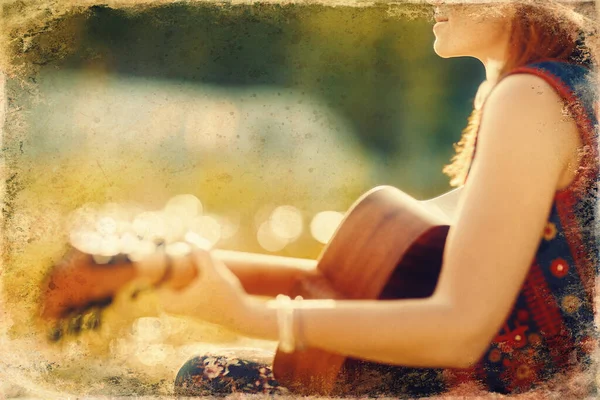 Woman playing with guitar and blurred background. Old photo effect. — Stock Photo, Image