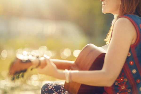 Mooie vrouw spelen met gitaar in de natuur. — Stockfoto