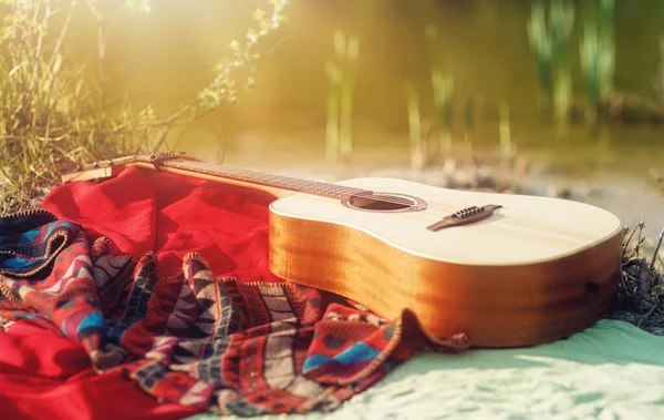 Guitare sur une couverture au sol dans la nature. — Photo