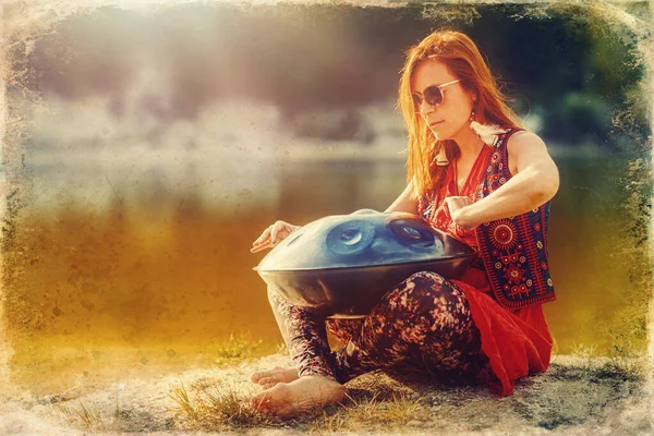 美しい女性が大自然の中でハングドラムで遊ぶ。古い写真効果. — ストック写真