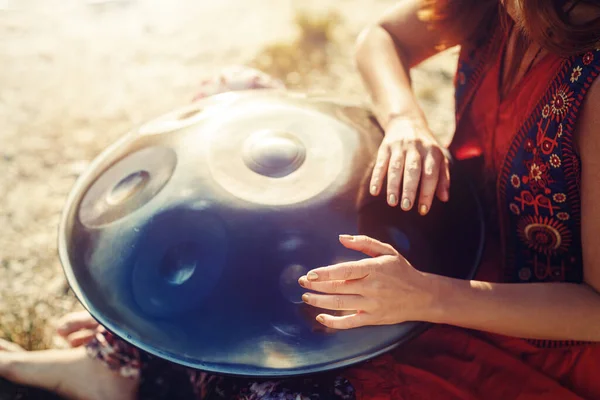 Beautiful woman playing with hangdrum in nature. — Stock Photo, Image