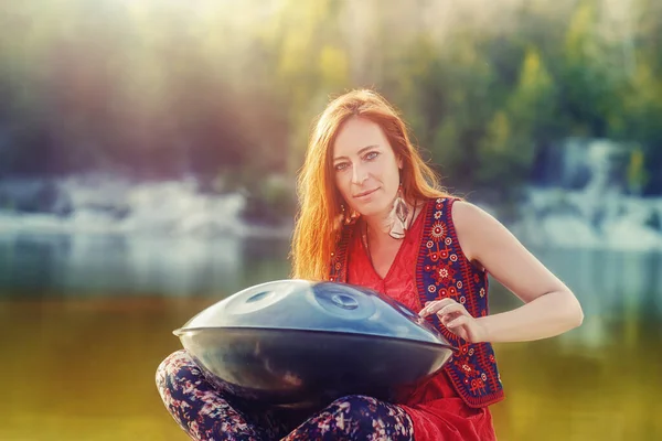 Schöne Frau, die in der Natur mit der Trommel spielt. — Stockfoto