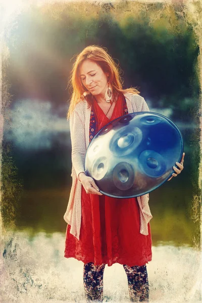 Beautiful woman playing with hangdrum in nature. Old photo effect. — Stock Photo, Image