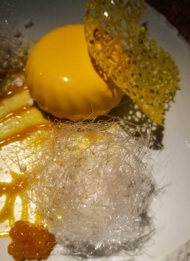 Mango dondurma ve seramik plaka üzerinde çeşitli süslemeler ile Mango cheesecake