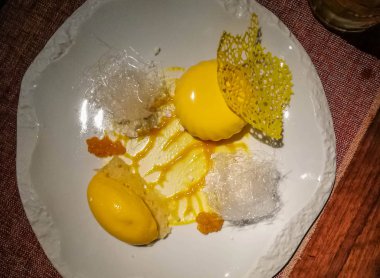 Mango dondurma ve seramik plaka üzerinde çeşitli süslemeler ile Mango cheesecake