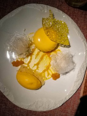 Mango dondurma ve seramik plaka üzerinde çeşitli süslemeler ile Mango cheesecake