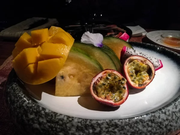 Exotic  fruit plate with mango, passion fruit, yellow watermelon and dragon fruit