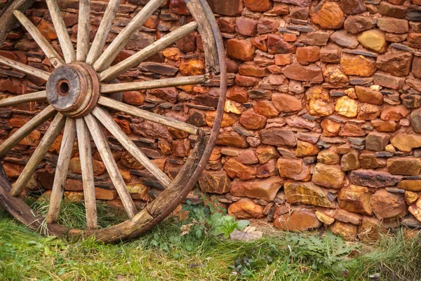Wall with masonry and wooden cart wheel in one of  red cities of Spain  Villacorta