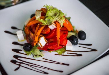 Yunan salatası görüntüsünü dekore edilmiş bir kare beyaz tabağında, seçici odak