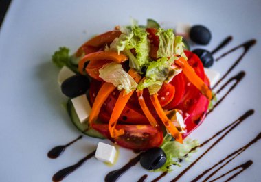 Yunan salatası görüntüsünü dekore edilmiş bir kare beyaz tabağında, seçici odak