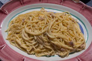 Pembe seramik tabakta spagetti carbonara resmi, İtalya 'nın Amalfi kıyısında.