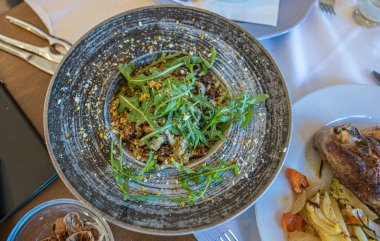 Kurutulmuş domatesli ev yapımı makarna roka ve özel soslu tasarım tabağı, seçici odaklı.