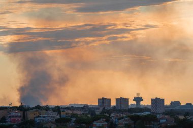 Roma, İtalya 'da gün batımının erken saatlerinde gökyüzünde çıkan bir yangının dumanı.