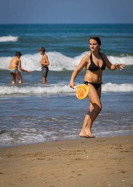 Bufalara, İtalya - 26 Ağustos 2020, Coronavirus salgını sırasında İtalya 'nın Bufalara plajında plaj tenisi oynayan genç bir kız