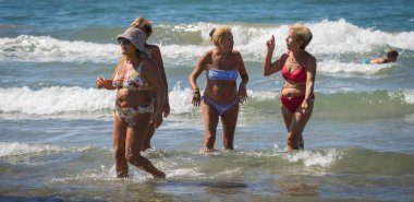 Bufalara, İtalya - 26 Ağustos 2020, plajdaki maskesiz kadın grupları sosyal mesafeyi korumazlar. İtalya 'da ikinci koronavirüs dalgası (covid19)