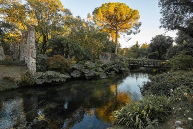 İtalya 'nın Latina eyaletindeki Nymph Gardens' ta günbatımında nehir ve yansımaların görüntüsü