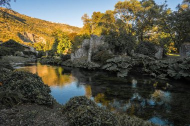 İtalya 'nın Latina eyaletindeki Nymph Gardens' ta günbatımında nehir ve yansımaların görüntüsü