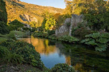 İtalya 'nın Latina eyaletindeki Nymph Gardens' ta günbatımında nehir ve yansımaların görüntüsü