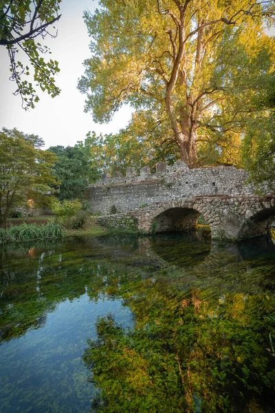 イタリアのラティーナ県のニンフ庭園の水にアーチと反射を持つ石の橋のイメージ — ストック写真